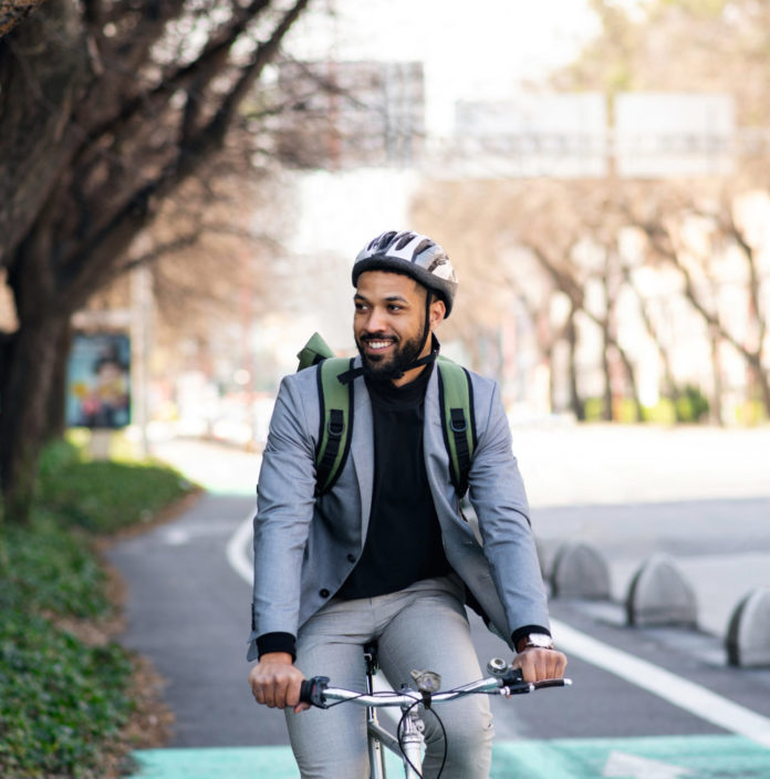 Portrait of man commuter riding bicycle in city, sustainable lifestyle.