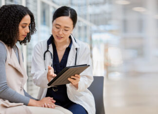 Gendermedizin: Warum sie für uns alle wichtig ist Doctor, woman patient and tablet for consulting with results, medical info and talk for healthcare with mockup space. Japanese medic, digital touchscreen or show video for surgery, wellness or advice.